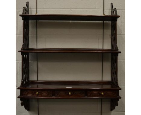 A three tier hanging shelf with three base drawers decorated with blind and pierced fret work 