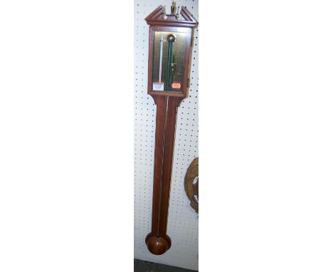 A reproduction mahogany stick barometer with brass dial