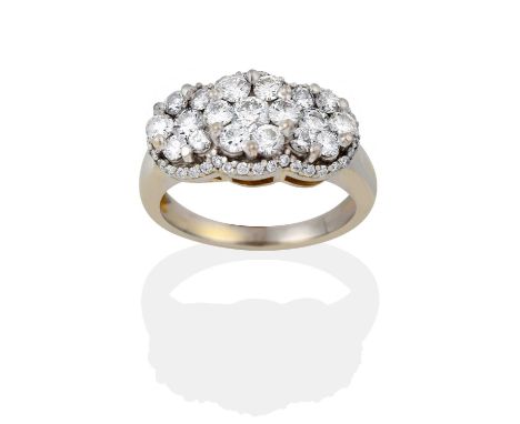 formed as three clusters of round brilliant cut diamonds, within a border of smaller round brilliant cut diamonds, in white c