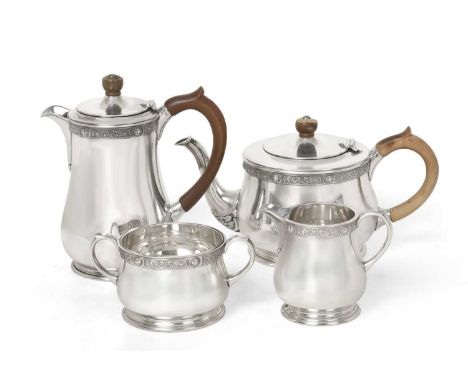 each piece tapering and on spreading foot, with Celtic style border, comprising: a teapot; a hot-water jug, each with wood ha