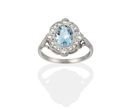 the oval cut aquamarine within a border of round brilliant cut diamonds, with larger diamonds at four points, in white milleg