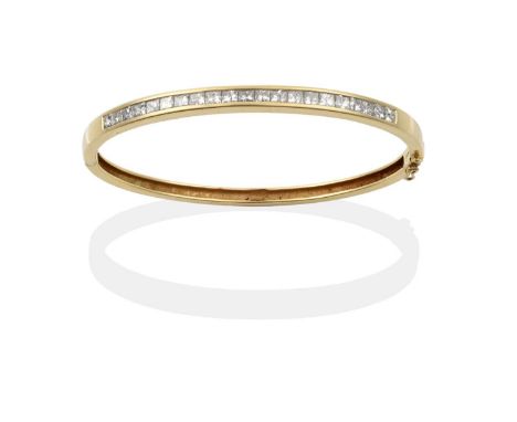 the princess cut diamonds in a yellow channel settings, to a plain polished hinged back, total estimated diamond weight 2.50 