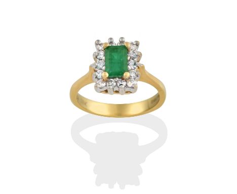 the emerald-cut emerald in yellow claw settings, within a border of round brilliant cut diamonds in white claw settings, to a