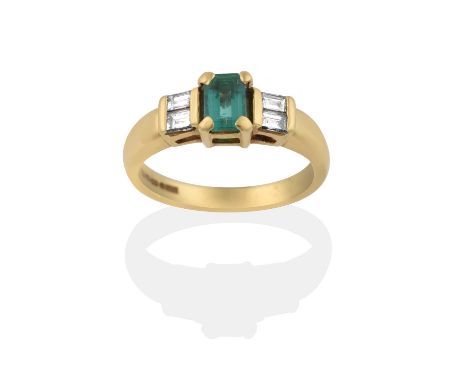 the emerald-cut emerald flanked by pairs of baguette cut diamonds, in yellow claw settings, to a tapered shoulder plain polis