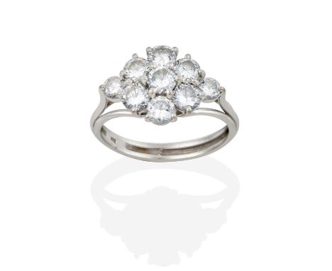 the round brilliant cut diamonds arranged in a kite-shaped formation, in claw settings, to a tapered shoulder triple row plai