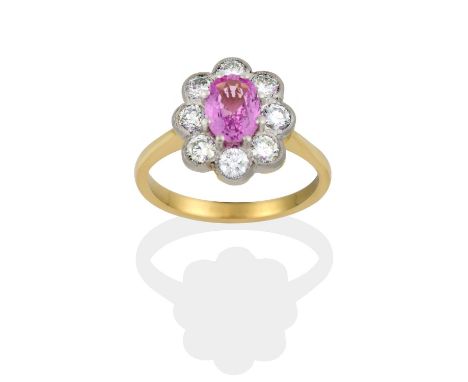 the oval cut pink sapphire within a border of round brilliant cut diamonds, in white claw and millegrain settings, to a yello