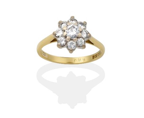 the round brilliant cut diamond within a border of smaller round brilliant cut diamonds, in white claw settings, to a yellow 