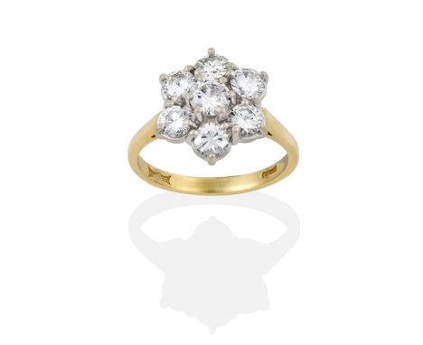 the round brilliant cut diamond within a border of smaller round brilliant cut diamonds, in white claw settings, to a yellow 