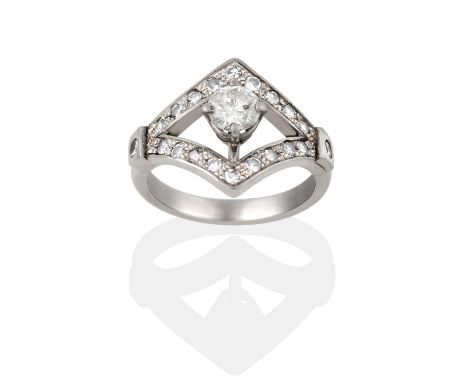 the round brilliant cut diamond in a kite-shaped border set throughout with round brilliant cut diamonds, in white claw setti