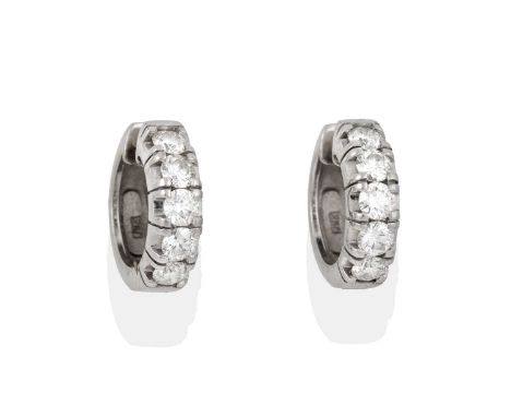 the round brilliant cut diamonds in white claw settings, to a plain polished hinged back, total estimated diamond weight 1.50