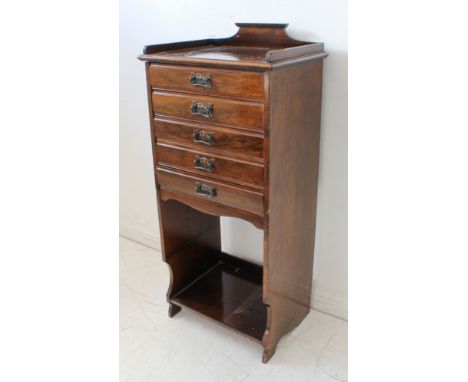 An Edwardian stained-wood music cabinet; three-quarter galleried top above five full-width drawers retaining coppered Art Nou