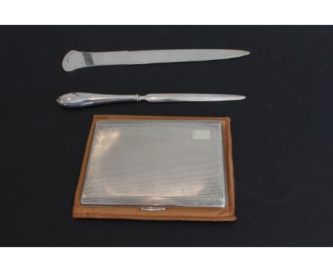 A George VI silver cigarette case, W. H. Manton Ltd., Birmingham 1951, bevelled rectangular form with engine turned decoratio