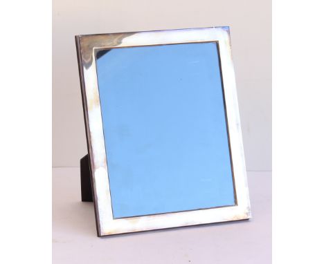 A modern photograph frame with silver outer, Sheffield assay marks and wooden back and easel style hinged stand (frame size 3