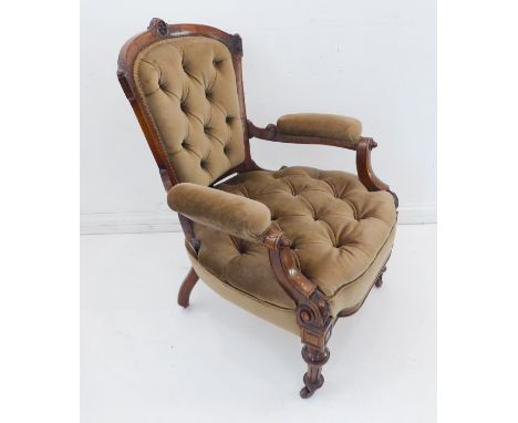 A fine walnut buttonback-upholstered open armchair: the top rail centrally carved and incised with floral and foliate motifs,