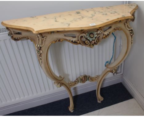 A marble-topped serpentine-fronted console table in mid-18th century Louis XV style; painted and carved in relief with gilt C