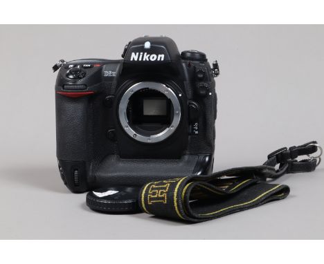 A Nikon D2H DSLR Camera body,  serial no 2033910, body G, light wear, with body cap, strap, battery and MH-21 charger
