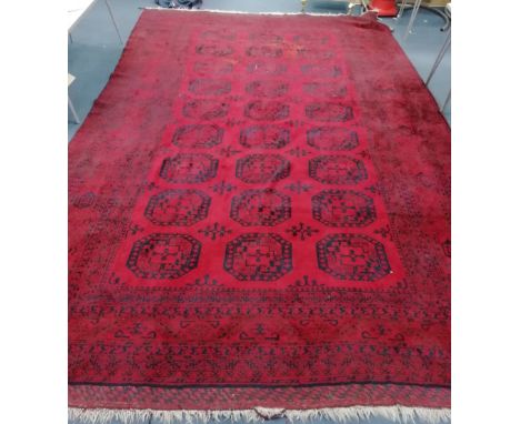 A large Afghan red ground carpet, 490 x 315cm