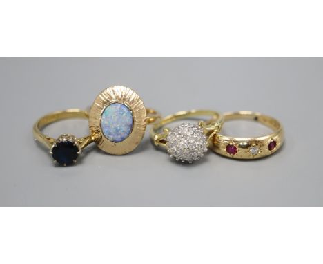 Three 18ct gold dress rings: diamond cluster, size K, ruby and diamond three stone, size O and synthetic sapphire, size L, an