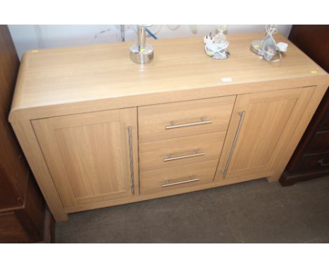 A light oak effect sideboard fitted three drawers