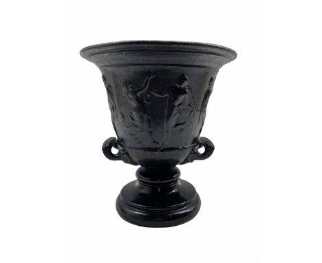 19th century black painted iron two handled pedestal vase, with a raised frieze of dancing and musical figures on a ceramic f