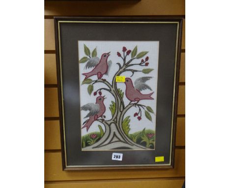 A framed embroidered crewel work panel of birds on a branch