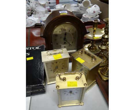 A vintage oak arch-topped mantel clock together with three modern battery carriage clocks