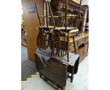 A good vintage oak gate leg dining table together with four matching wheel back loose cushion dining chairs