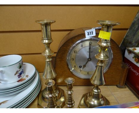 A vintage oak cased domed top mantel clock by Garrard & two pairs of brass candlesticks