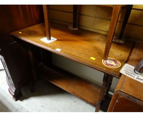 An Edwardian oak console-style table with lower shelf & on castors