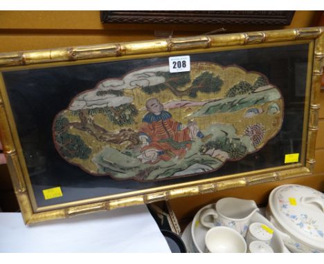 A framed gilt & painted Oriental panel depicting a seated male under a tree