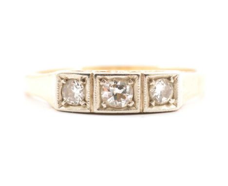 A diamond three stone ring, the brilliant cut stones square set in a yellow and white metal mount marked 585, scroll decorati