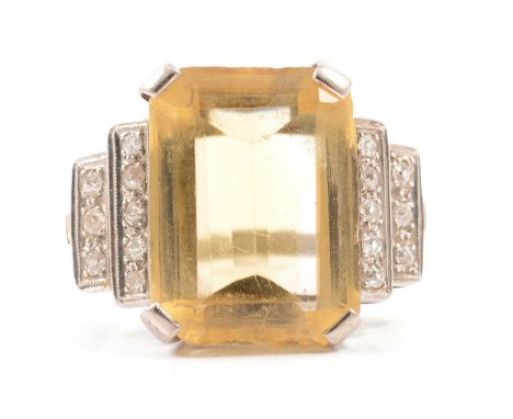 A lady's large citrine and diamond dress ring, the step cut citrine 18.5x14mm, four claw set in a platinum mount with eight o