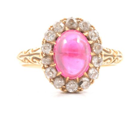 A ruby and diamond cluster ring, the oval cabochon cut ruby 8.5x6.5mm, claw set and surrounded by fourteen old cut diamonds, 