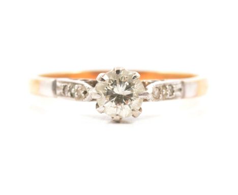 A diamond solitaire ring, the brilliant cut stone claw set in a yellow and white metal mount marked 18ct, two 8 cut diamonds 