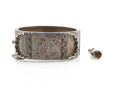 A Victorian silver half hinged bangle, 25mm wide with raised detail and floral engraving to front, internal dimensions 55x47m