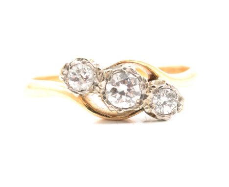 A diamond three stone crossover ring, the brilliant cut stones illusion set in a yellow and white metal traditional three sto