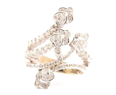A diamond set dress ring of crossover design terminating in hearts and trefoils in an all white metal mount stamped 750, the 