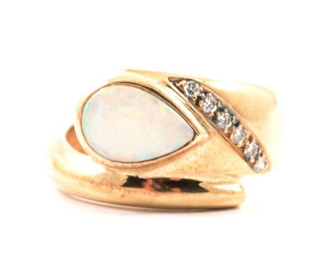 A modern opal and diamond ring, a pear shaped cabochon cut opal collet set in a 9 carat yellow and white gold crossover mount