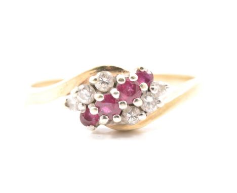 A ruby and diamond crossover ring, four small rubies and six brilliant cut diamonds claw set in an 9 carat yellow and white g