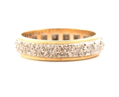 A diamond full eternity ring, twenty-one 8 cut diamonds in white metal star shaped settings and flanked each side by a yellow