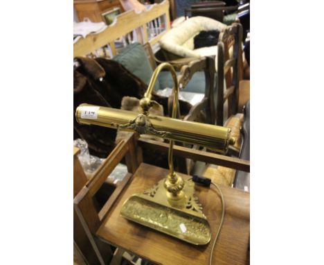 A brass desk lamp with pen tray section 
