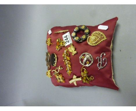 Pillow covered in vintage costume jewellery brooches