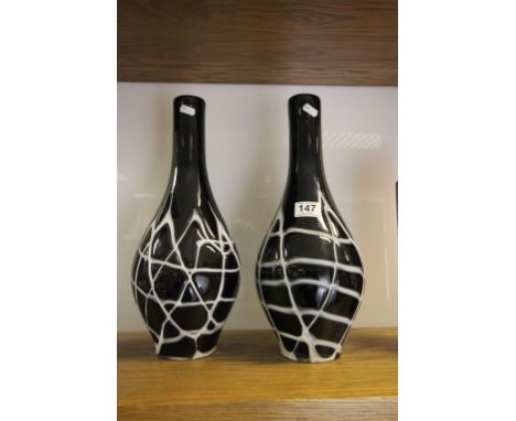 A large pair black art glass bottle vases