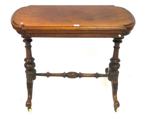 A Victorian mahogany card table
The shaped hinged and swivel top enclosing a green baize lined interior, above twin turned an