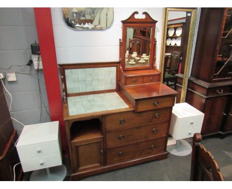 In the manner of "Maple &amp; Co" a late Victorian walnut combination washstand dressing chest, the tilt mirror over six draw