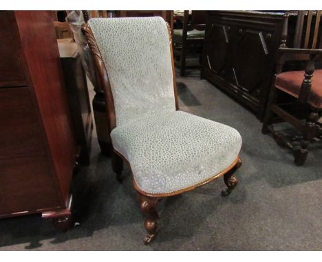 An early Victorian walnut nursery open armchair with carved acanthus leaf scroll back rest over carved cabriole legs and cera