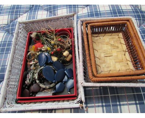 A selection of costume jewellery including a wide red bangle with a white stripe and four wicker baskets