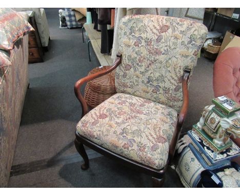 An Edwardian open arm desk chair with floral tapestry upholstery on cabriole legs