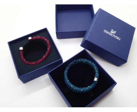 Two Swarovski bangles one in ruby coloured crystals with stainless steel terminals and the second longer bangle in aquamarine