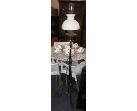 A WROUGHT IRON AND BRASS OIL STANDARD LAMP